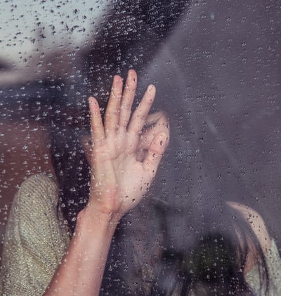 女人触摸玻璃雨
